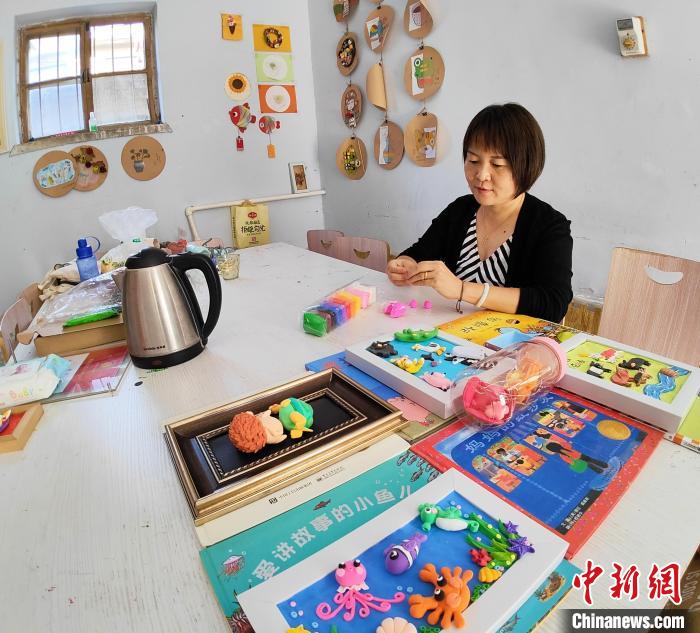 張美正在準(zhǔn)備給孩子們講故事用的道具?！∠臅枣?攝