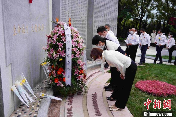 現(xiàn)場人員向人體器官捐獻者紀念碑獻花、鞠躬?！〈蘧办n 攝