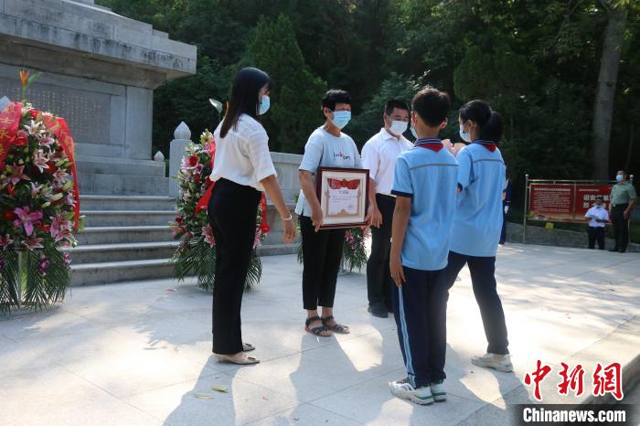 少先隊(duì)員向烈屬敬獻(xiàn)鮮花?！≌闹菔型艘圮娙耸聞?wù)局供圖