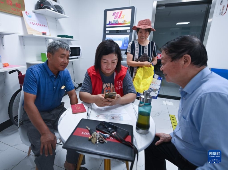 在浙江省杭州市臨安區(qū)玲瓏街道東山社區(qū)便民服務(wù)站，黨員志愿者幫助居民填寫公租房申請資料（2022年8月17日攝）。新華社記者 徐昱 攝