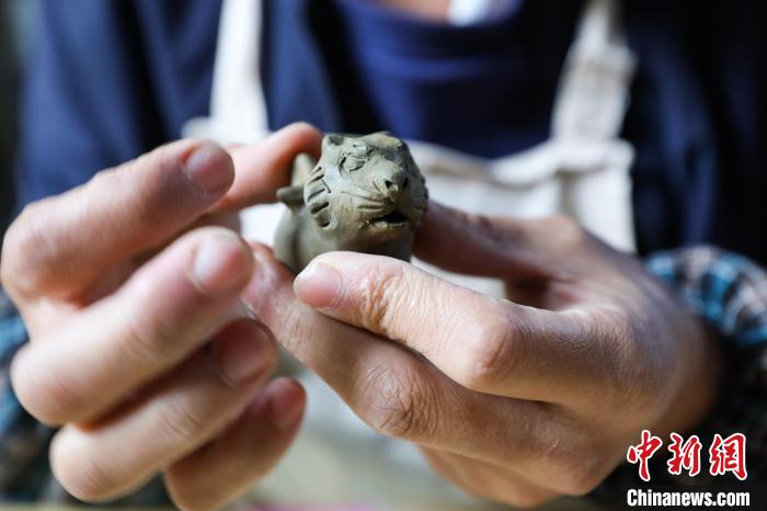 姚德波捏制的老虎形狀“桐梓泥哨”?！■暮陚?攝