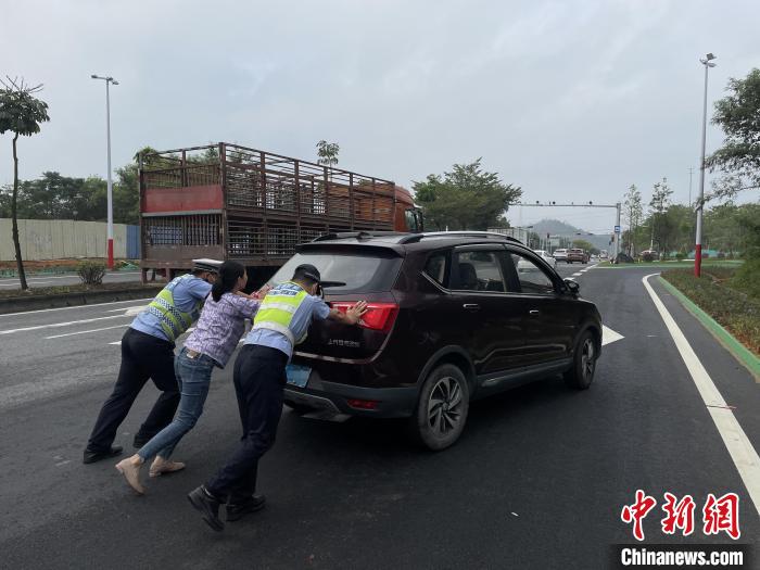 佛山高明公安警輔人員協(xié)助司機(jī)將故障車輛推至安全區(qū)域?！∥轲┤?攝