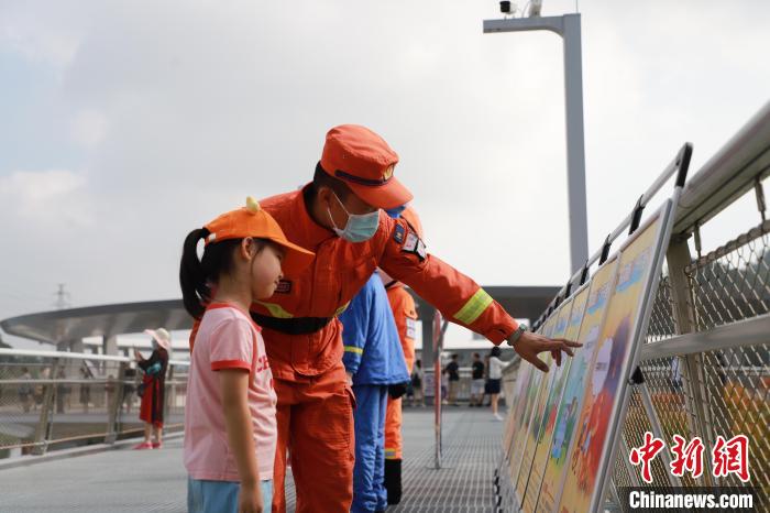 森林消防員正在防火宣傳展板前與小朋友進(jìn)行科普講解?！↑S山鴻 攝