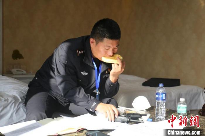 圖為李輝一邊吃飯一邊工作?！“蕉疾既?攝