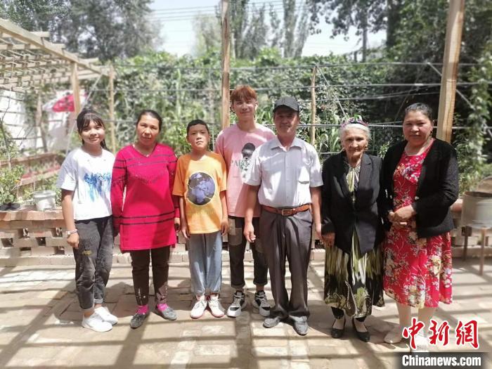 108歲老人努爾·依地?zé)崴?右二)喜愛勞作，澆花，喂羊，烤包子等都親力親為。圖為老人與部分子孫?！≈炀俺?攝