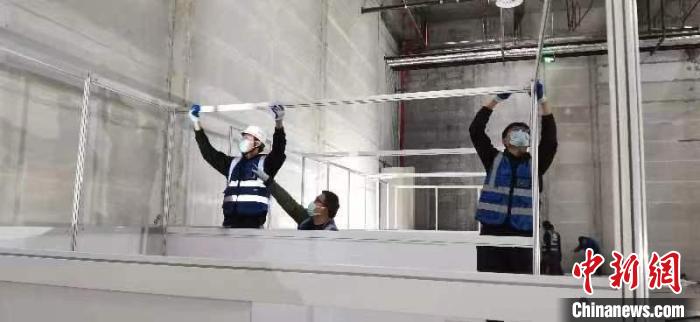 圖為工人搭建方艙醫(yī)院現(xiàn)場?！《毠﹫D