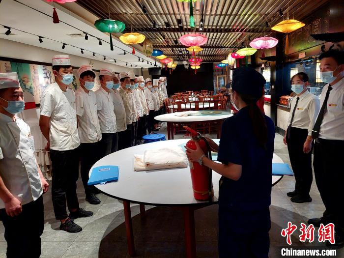 檢查期間，消防協(xié)管員為一家飯店后廚工作人員普及消防知識(shí)。　張帥帥 攝