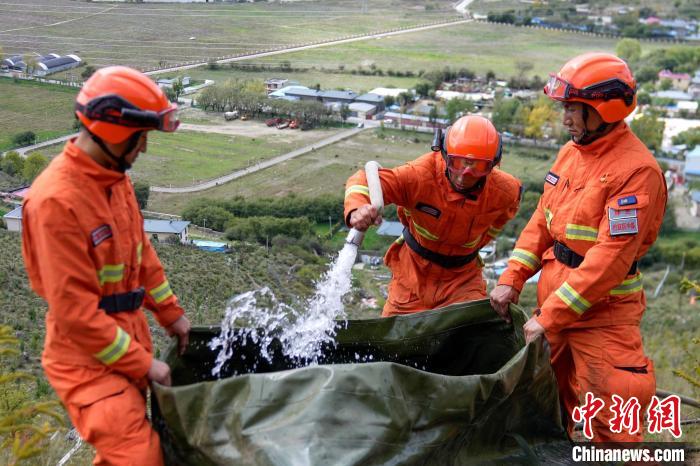 技能大練兵過程中，消防員在陡坡上向蓄水池注水?！±顕鵂c 攝