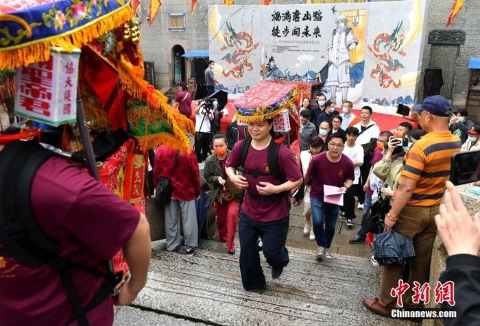 資料圖：5月12日，“福滿唐山路·徒步向未來”2022年兩岸青年信俗淵源尋根之旅活動(dòng)在福建福州啟幕，30多名閩臺(tái)青年恭請(qǐng)“福神”，背著端坐有關(guān)公、陳文龍神像的轎子從福州臺(tái)江區(qū)三通橋頭出發(fā)，開啟一場(chǎng)祖脈尋根之旅。 <a target='_blank' href='/'>中新社</a>記者 呂明 攝