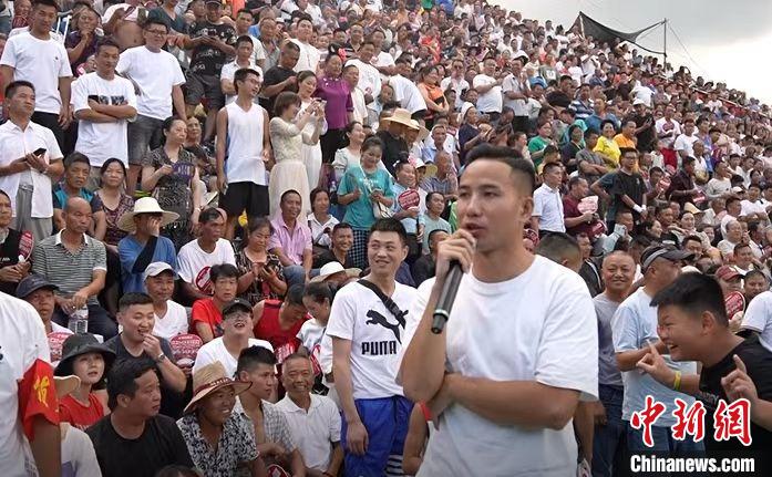圖為臺盤村村民王再貴擔(dān)任球賽解說。　袁超 攝