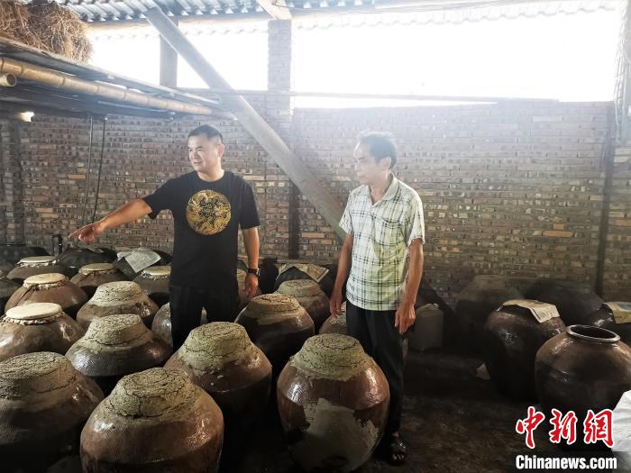 吳善遠(yuǎn)(左一)上門向農(nóng)戶收購(gòu)黃酒?！∑聊峡h委組織部 供圖