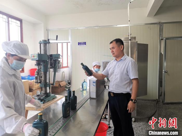 吳善遠(yuǎn)(右一)檢查黃酒包裝是否達(dá)標(biāo)?！∑聊峡h委組織部 供圖