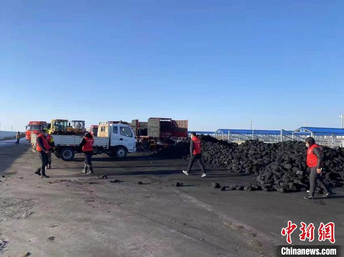 圖為工作人員正在協(xié)助牧民裝煤。　寶音都蘭 攝