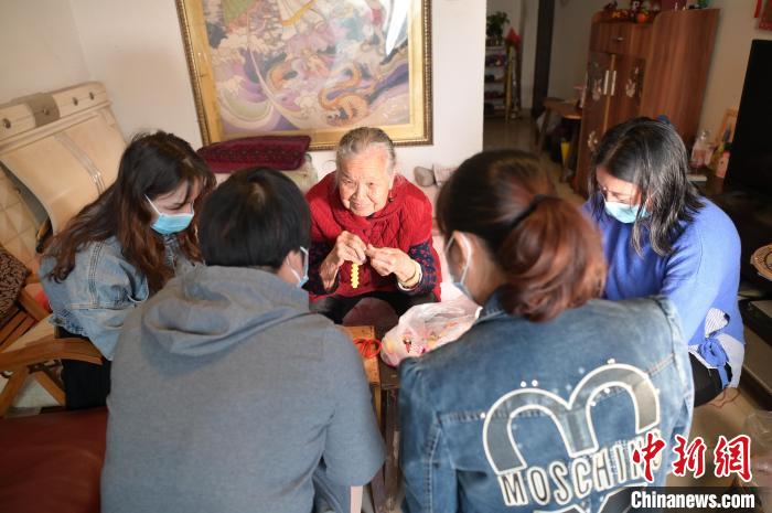 圖為周有玉在家中教授居民串珠手工藝品制作技藝?！￡愽?攝