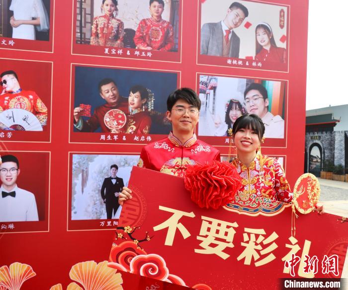 圖為參加“不要彩禮要幸?！奔w婚禮的新人在合影留念?！⒂駶?攝
