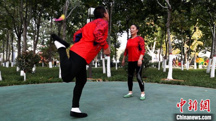 圖為白賀成(左一)和毽友在公園踢毽。　臧振清 攝