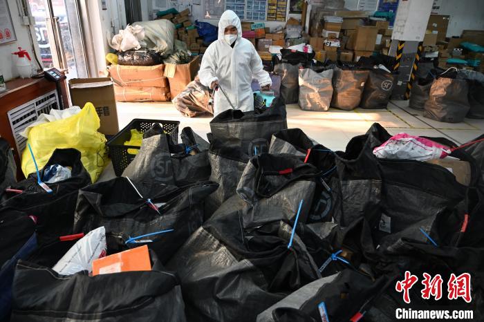 圖為工作人員正在對快遞包裹進行消殺。　劉文華 攝