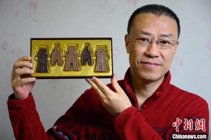 山西平面廣告設(shè)計(jì)師孫晟展示他設(shè)計(jì)制作的布幣巧克力?！№f亮 攝