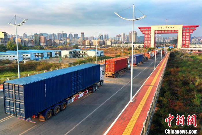 物流貨車在廣西東興二橋上排隊進(jìn)關(guān)?！≈苘?攝