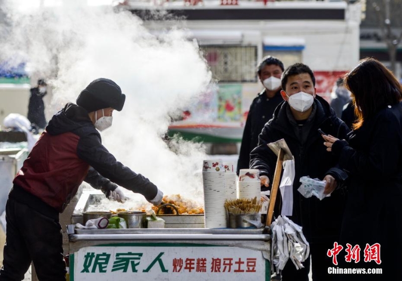 資料圖：外出購(gòu)物的市民購(gòu)買品嘗街頭小吃。 劉新 攝