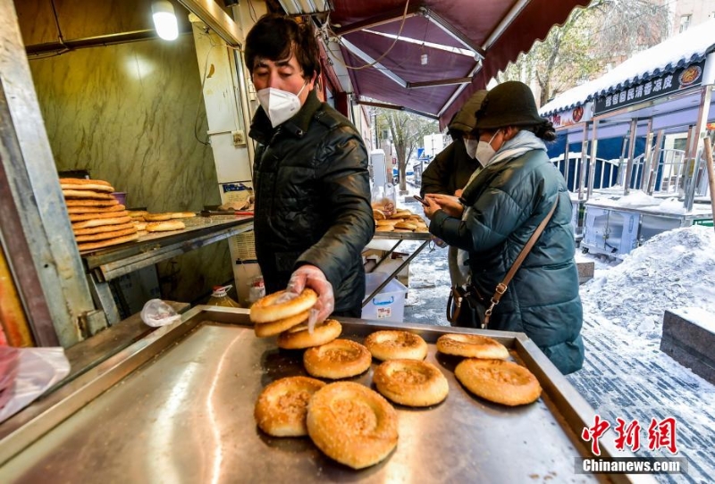 烏魯木齊市文化路，已開門營(yíng)業(yè)的馕店吸引過往市民前來購(gòu)買。 劉新 攝