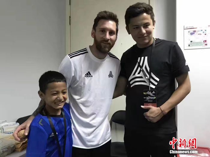 阿布都拉哈力克·艾木杜拉和他的體育老師在北京，與梅西合影。葉城縣教委供圖