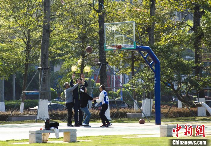 圖為市民、游客在防城港市公園廣場打籃球?！〉岳顝?攝