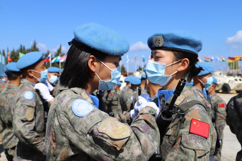 圖為2021年6月16日，在黎巴嫩南部辛尼亞村中國維和營舉行的授勛儀式上，接受檢閱的維和女兵進場前互相整理著裝。（新華社發(fā)）