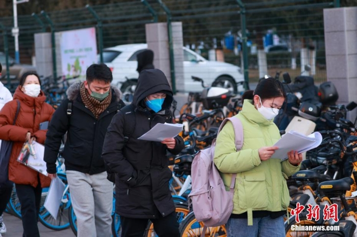 12月24日，2023年全國(guó)碩士研究生招生考試正式開考，全國(guó)報(bào)考人數(shù)為474萬(wàn)。圖為北京工業(yè)大學(xué)考點(diǎn)外，考生在進(jìn)入考場(chǎng)前加緊復(fù)習(xí)。 <a target='_blank' href='/'>中新社</a>記者 賈天勇 攝