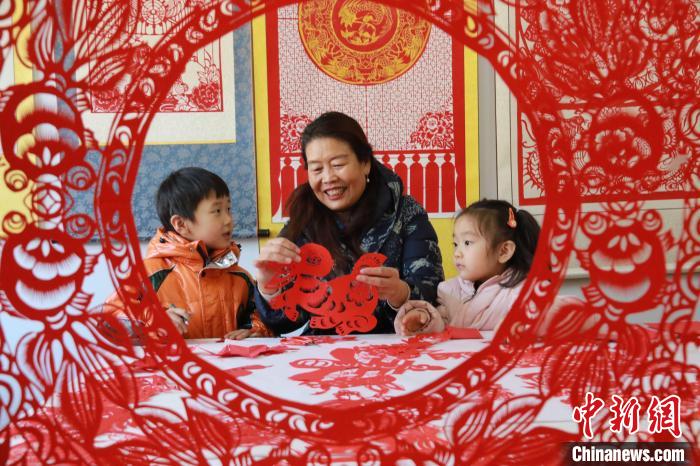非遺傳承人田桂芹在帶領(lǐng)孩子們進(jìn)行迎新年剪紙創(chuàng)作。　李海濤 攝