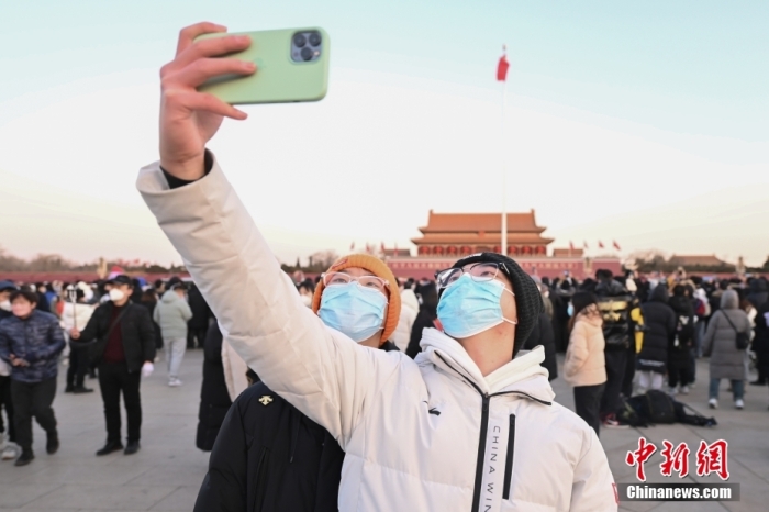 2023年1月1日晨，北京天安門廣場舉行隆重的升國旗儀式。人們來到天安門廣場觀看升旗儀式，迎接新年。圖為市民拍照留念。 <a target='_blank' href='/'>中新社</a>記者 趙文宇 攝