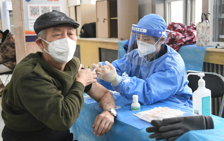 2022年12月15日，在北京市海淀區(qū)中關村街道新冠疫苗接種點，醫(yī)護人員為老年人接種新冠疫苗。（圖源：新華社）