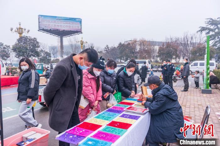圖為村民在圍觀(guān)莒縣過(guò)門(mén)箋制作?！￡惞饨?攝
