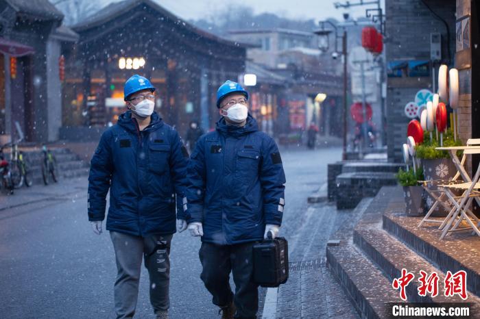 國網(wǎng)北京石景山供電公司職工在模式口村開展電力設(shè)備巡視工作，保障居民用電?！〗?攝