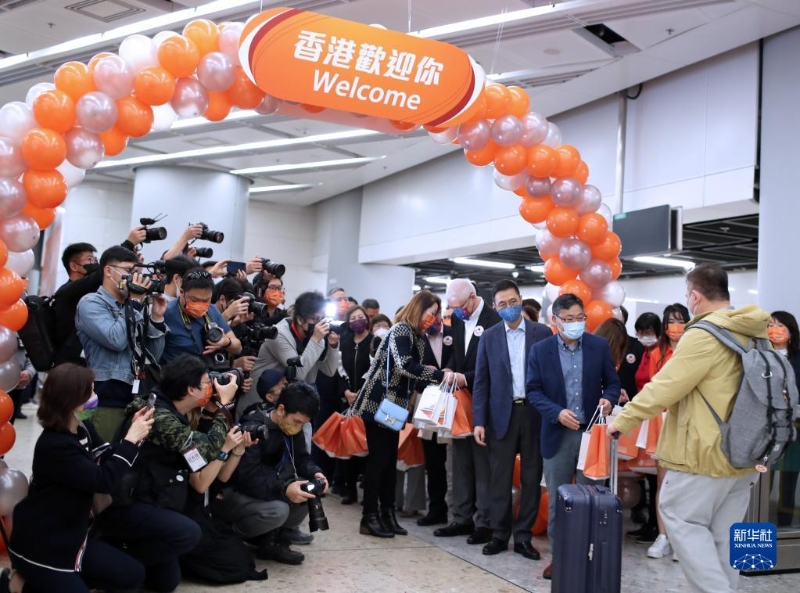 1月15日，在香港的西九龍站，工作人員迎接恢復(fù)通車后內(nèi)地駛往香港首趟列車的旅客并贈(zèng)送小禮物。新華社記者 李鋼 攝