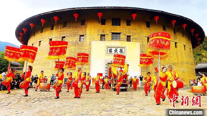 為豐富節(jié)日旅游內容，永定土樓景區(qū)白天推出了大鼓涼傘舞等非遺項目表演?！∮蓝ㄍ翗蔷皡^(qū)供圖