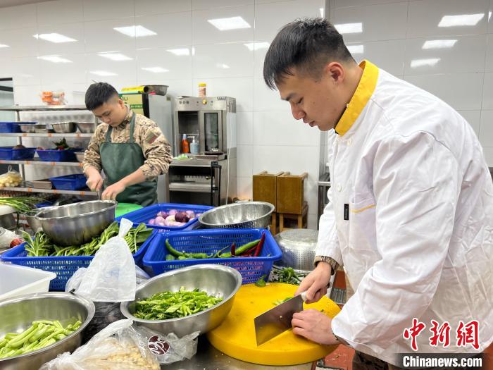 干部們在廚房切菜?！∥渚憬傟犈_州支隊供圖