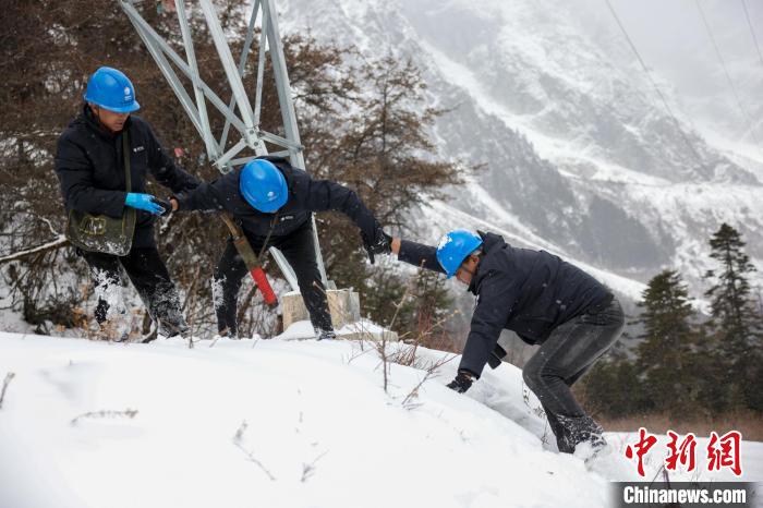 西藏波密縣電力巡護(hù)人員相互幫助，趟雪踏冰?！±顤|淮 攝