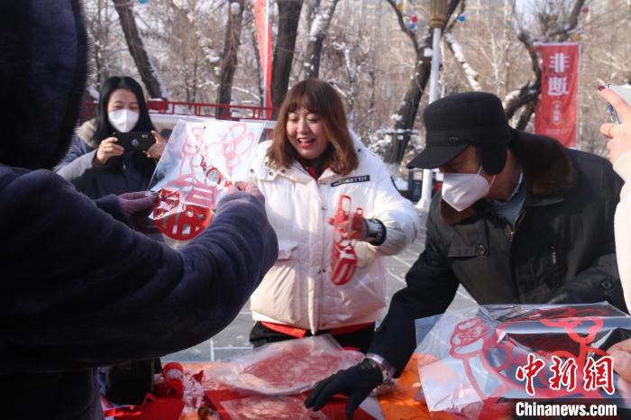 一張張寄托著美好祝愿的剪紙送給市民。　潘琦 攝