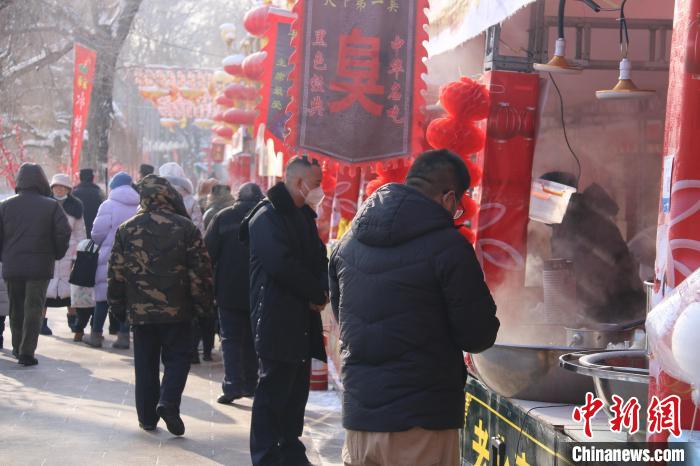 烏魯木齊市民在公園小吃攤上選購食品?！∨绥?攝
