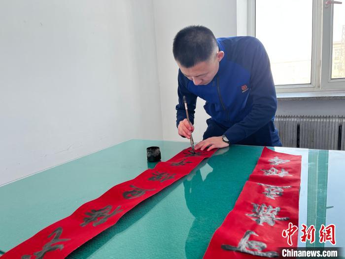 圖為森林消防指戰(zhàn)員自己動手寫春聯(lián)?！∶缱?攝