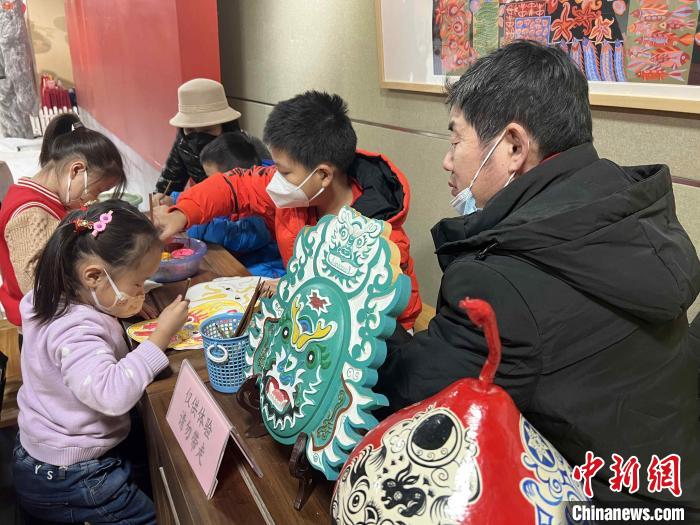 山東省級非遺侯氏社火臉譜傳承人侯志新在現(xiàn)場教小朋友畫臉譜?！∴嶊?攝