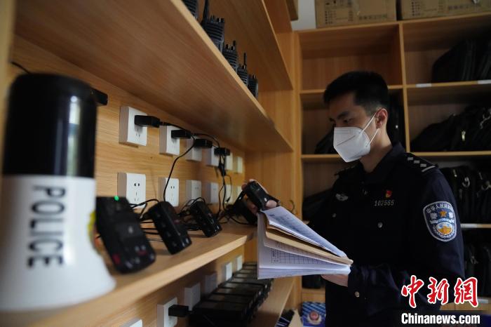 圖為民警黃昊正在清點整理執(zhí)法記錄儀?！⊥鯓s鑫 攝