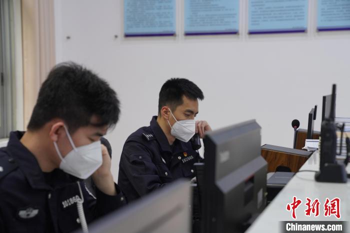 圖為民警黃昊與同事一同接聽報警電話。　王榮鑫 攝