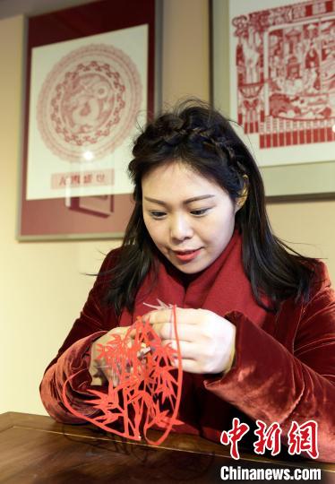 圖為梁巧艷在剪窗花?！⊥鯆赡?攝