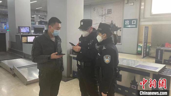 民警劉學(xué)強(qiáng)和李晨俊正在與旅客進(jìn)行交流?！±钚∨?攝