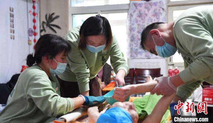 張慧和同事一起為老人進(jìn)行助浴服務(wù)。　受訪者供圖