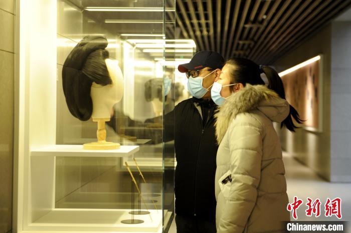 圖為市民觀賞古人發(fā)型展品?！「咪?攝