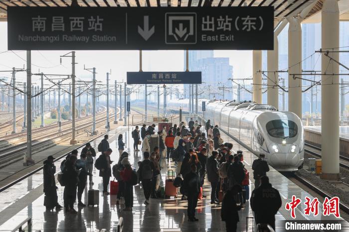 圖為江西南昌西站，一輛列車進(jìn)站，旅客有序在站臺(tái)上候車?！⒘?攝
