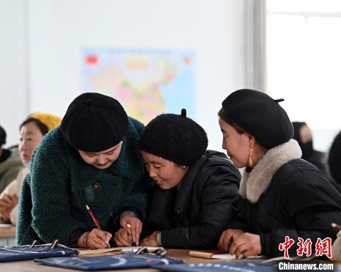 圖為甘肅廣河縣莊窠集鎮(zhèn)婦女，在老師指導(dǎo)下學(xué)習(xí)拼音。　九美旦增 攝